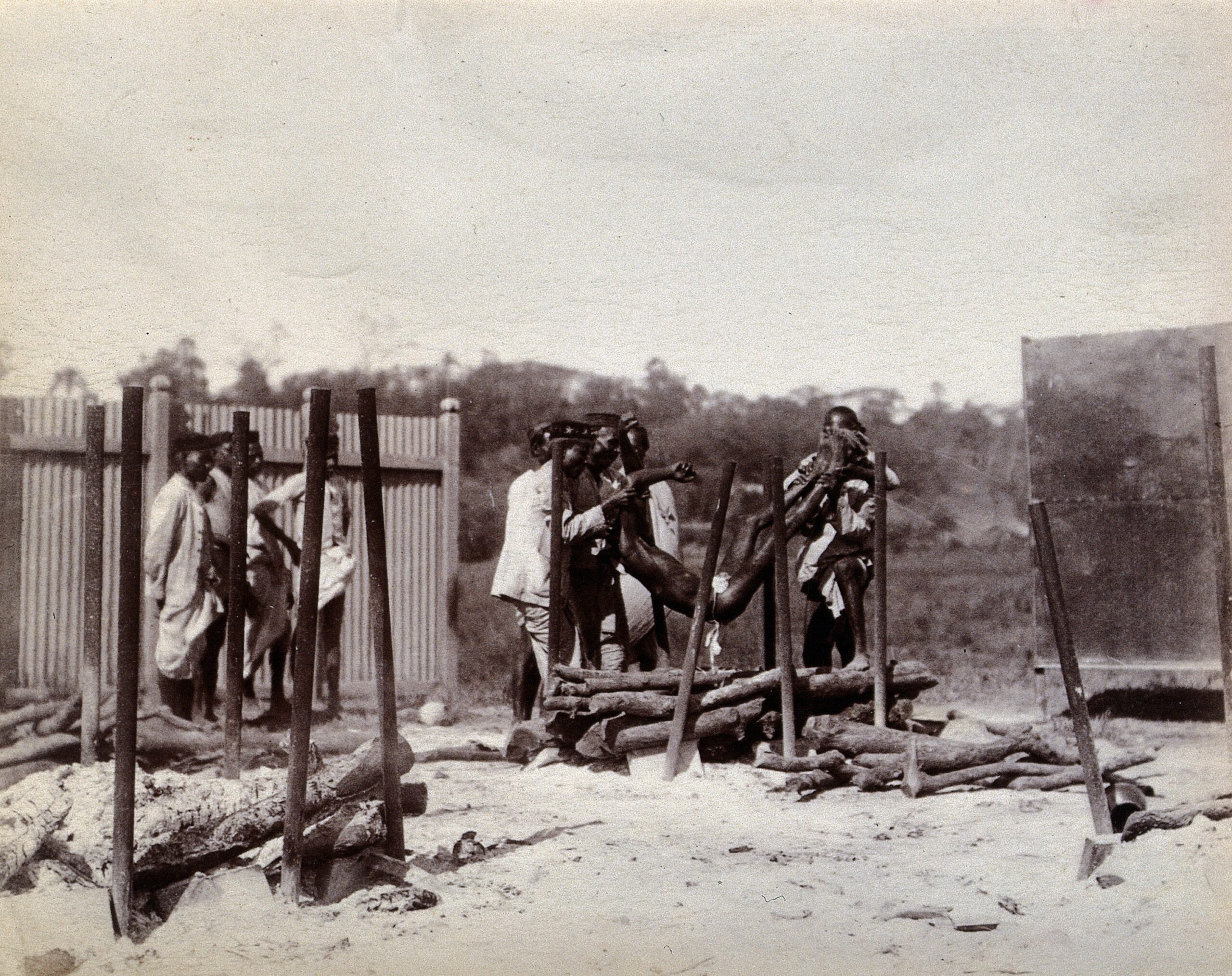 Un groupe d'hommes déposant le cadavre d'un pestiféré sur un bûcher pour sa crémation hindouiste, Bombay (1896-1897)
